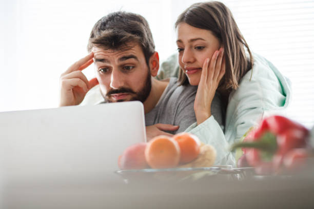 istock Worried couple using laptop at home 1173762656
