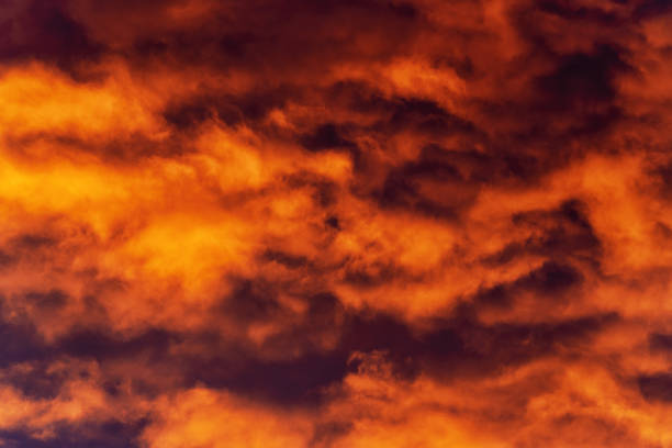 istock Golden clouds at sunset floating across violet and purple thunderclouds in sky 1173762706