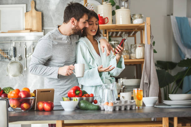 istock Young couple using smart phone in the kitchen 1173762711