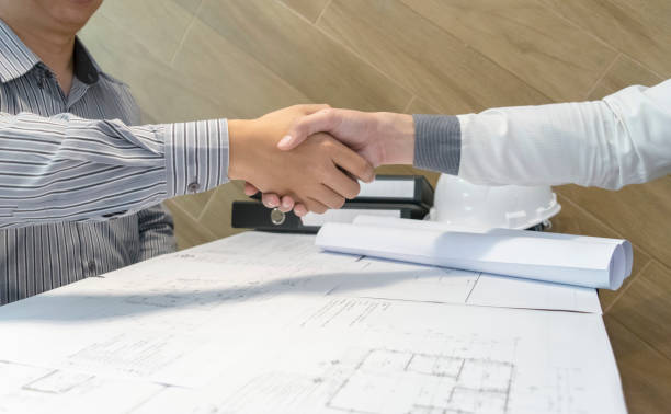 istock Business People Shaking Hands Over Papers On Table 1173764808
