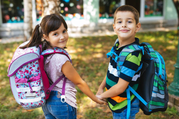 istock School children holding hands and going to school together 1173767307
