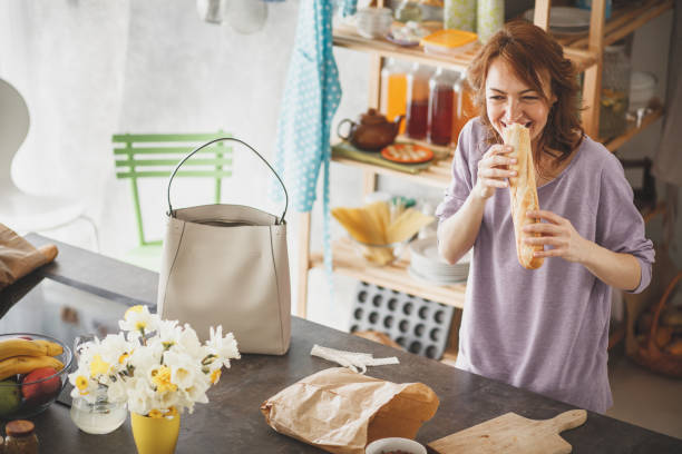 istock Woman eating fresh baguette in the kitchen 1173767363
