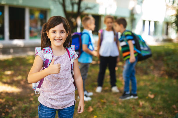 istock Happy elementary female student outside her school 1173767376