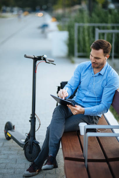 istock Businessman using digital tablet in the city park after scooter riding 1173767652