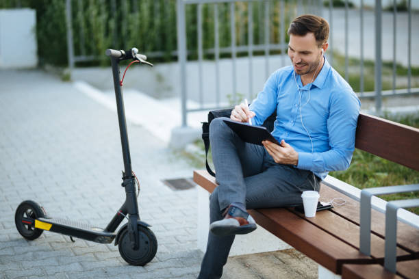 istock Businessman using digital tablet in the city park after scooter riding 1173768555