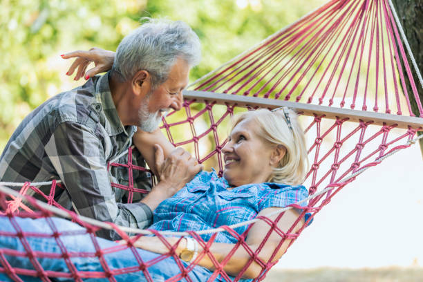 istock Senior couple smiling and relaxing in red striped hammock. 1173771025