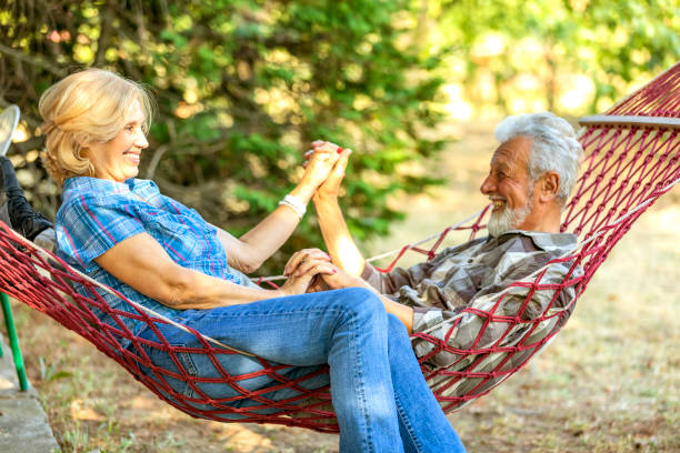 istock Senior couple smiling and relaxing in red striped hammock. 1173771153