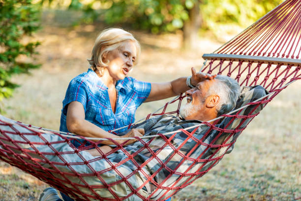 istock Senior couple smiling and relaxing in red striped hammock. 1173771911