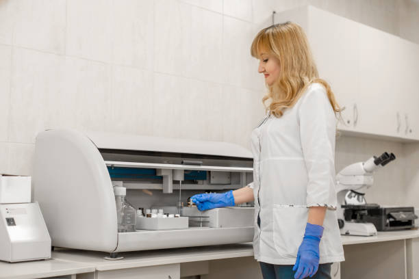 tecnico di laboratorio testa il sangue nell'analizzatore automatico del campione di sangue - automated lancet foto e immagini stock