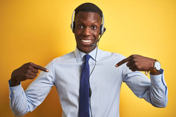 istock African american operator man working using headset over isolated yellow background looking confident with smile on face, pointing oneself with fingers proud and happy. 1173777029