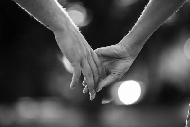 Young couple holding hands while walking on the field