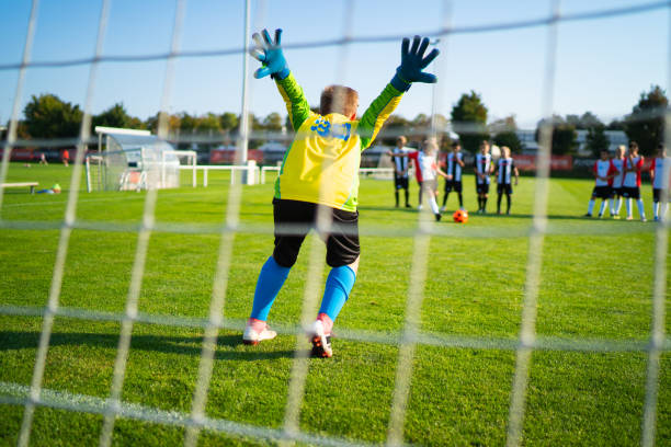 istock rear view professional young soccer goalkeeper viewed through goal net 1173777449