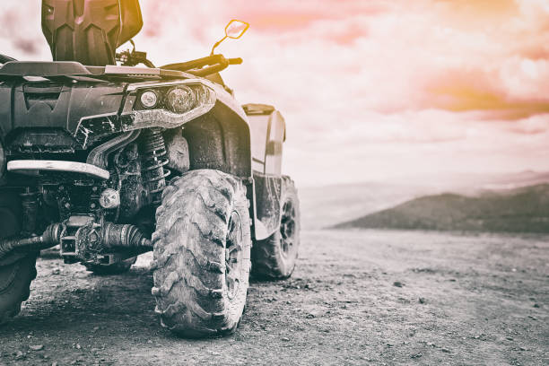 Quadricycle or quad bike on the mountains background on a cloudy day in black and white toned stock photo