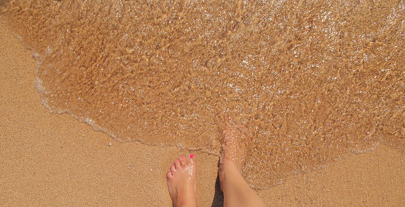 legs of a girl on the seashore. Selective focus. nature.