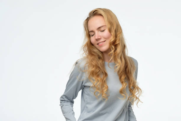 istock caucasian female looking down with shy smile, being embarrassed 1173781006