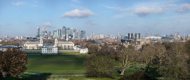 London, United Kingdom - February 02, 2019: Panorama of Canary Wharf skyscrapers, National Maritime museum in front, O2 arena on right side, as seen from Greenwich, during sunny day