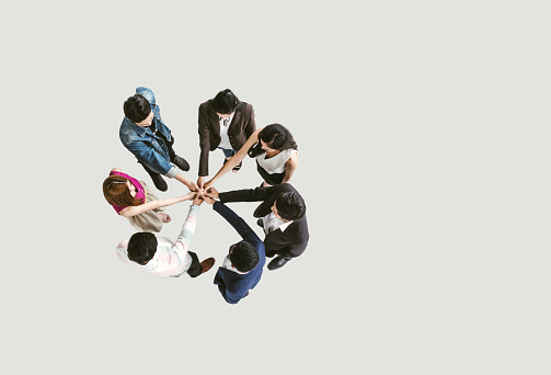 Top view of business people standing with their hands together in a huddle stack hand teamwork assemble together.