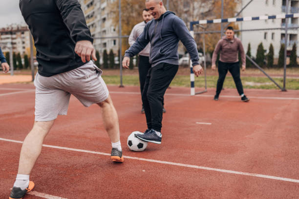 istock Men friends playing soccer 1173785007