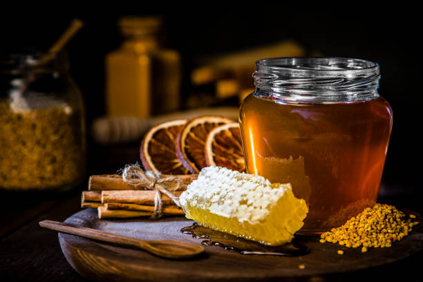 ハニカムとミツバチの花粉、乾燥オレンジとシナモンスティックの蜂蜜瓶 - bee honey bee single flower honey ストックフォトと画像