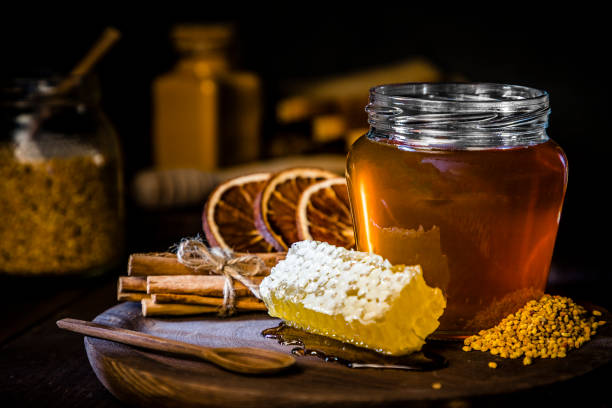 istock Honey jar with honeycomb and bee pollen, dried orange and cinnamon sticks 1173786174