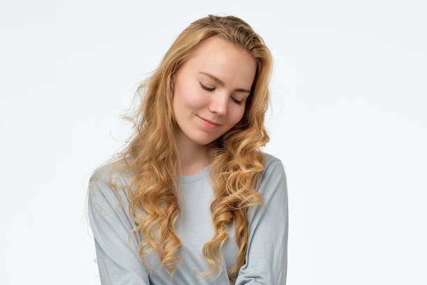 istock caucasian female looking down with shy smile, being embarrassed 1173786964