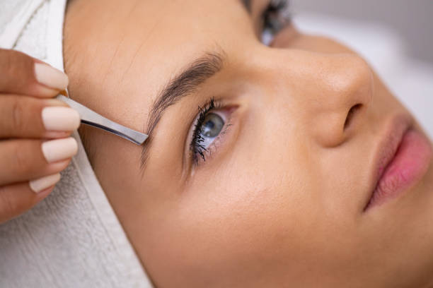 Beautiful young woman gets eyebrow correction procedure