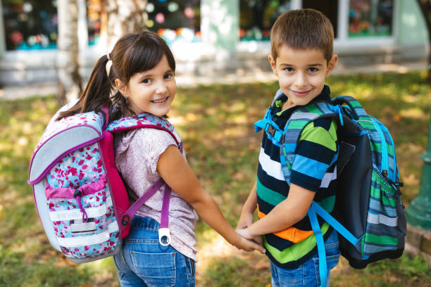istock School children holding hands and going to school together 1173790479