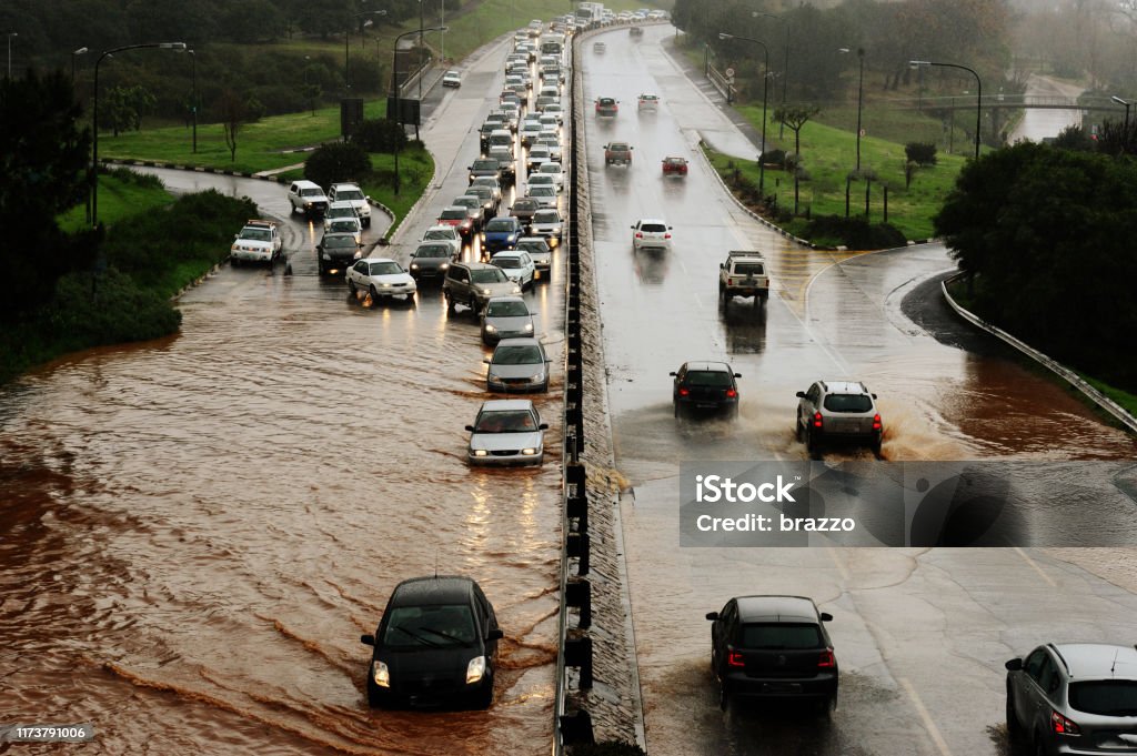 Flooding road Motorists drive through water on a flooding highway Flood Stock Photo
