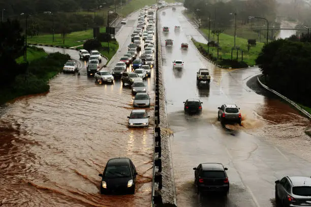 Motorists drive through water on a flooding highway