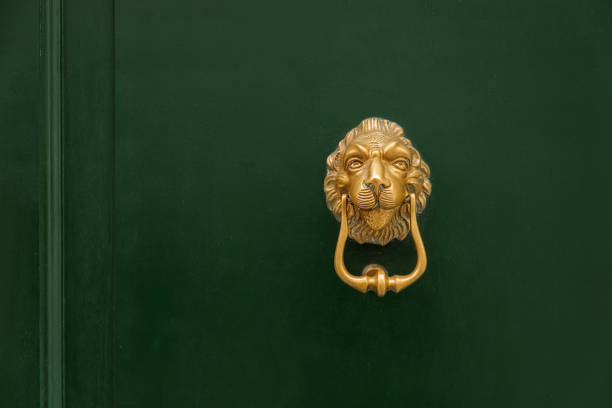 Golden lion-shaped door knocker on green front door in Venice, Italy Golden lion-shaped door knocker on green front door in Venice, Italy antique brass door handles stock pictures, royalty-free photos & images