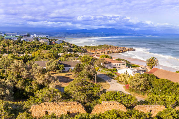 Plettenberg Bay a holiday destination in the Western Province of South Africa with the beachfront and holiday homes under a dramatic cloudy sky.