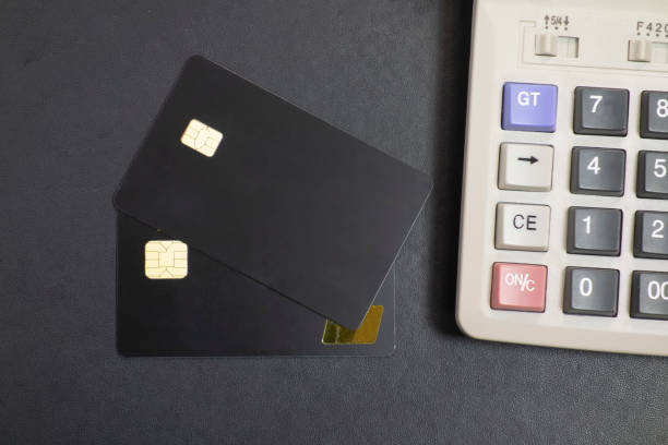 istock Bank cards and calculators in a black background 1173801306