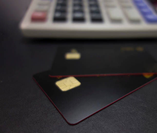 istock Bank cards and calculators in a black background 1173801333