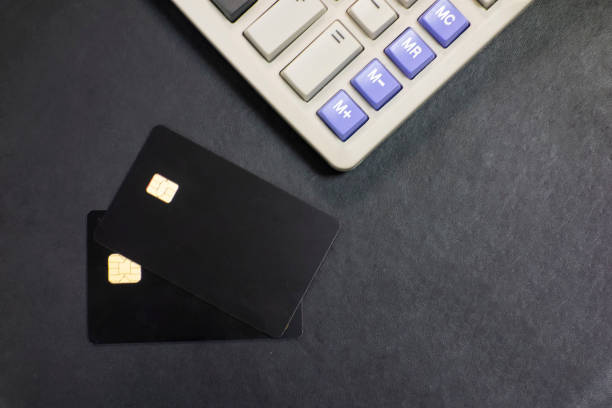 istock Bank cards and calculators in a black background 1173801365