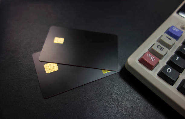 istock Bank cards and calculators in a black background 1173801369