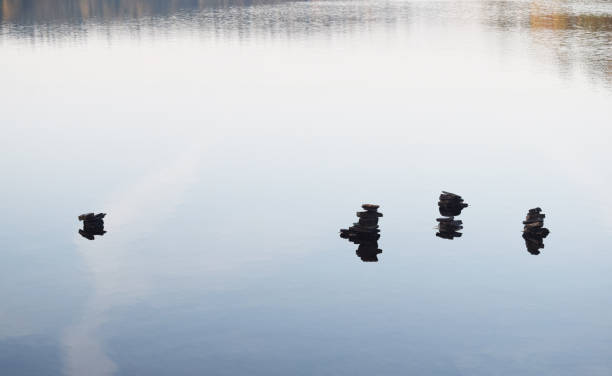 istock Stacked stones in water with reflections 1173801790