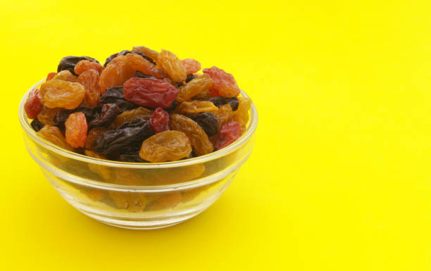 istock Raisins in bowl on yellow background 1173808773