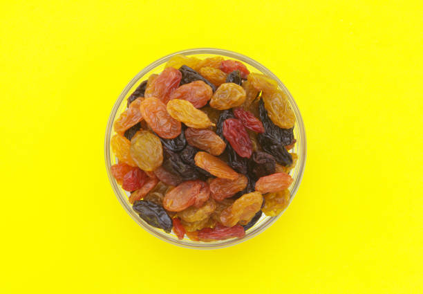 istock Raisins in bowl on yellow background 1173808954