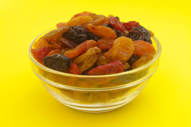 istock Raisins in bowl on yellow background 1173809849