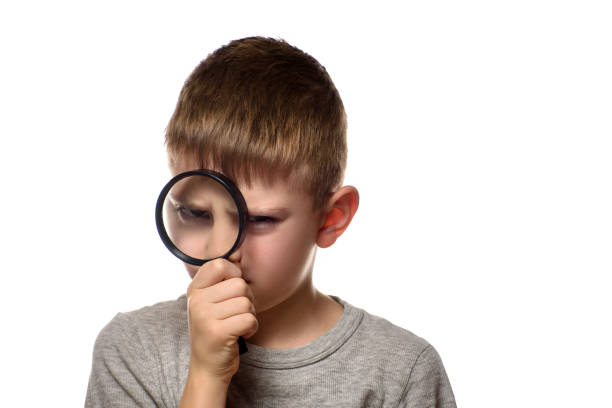 istock Boy with a magnifying glass in his hands. Little explorer. White background 1173812766