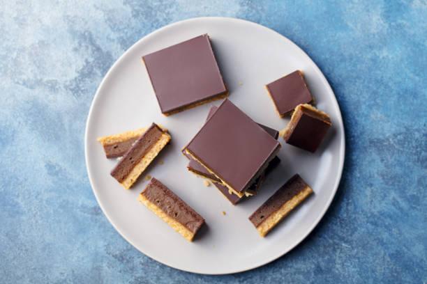 istock Chocolate caramel slices, bars, millionaires shortbread on a plate. Blue background. Top view. 1173813353