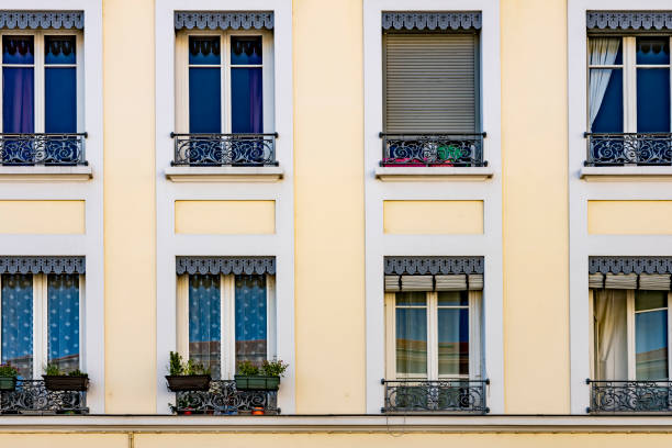 Apartment building exterior in Lyon with window boxes and plants in two storeys of upstairs apartments.