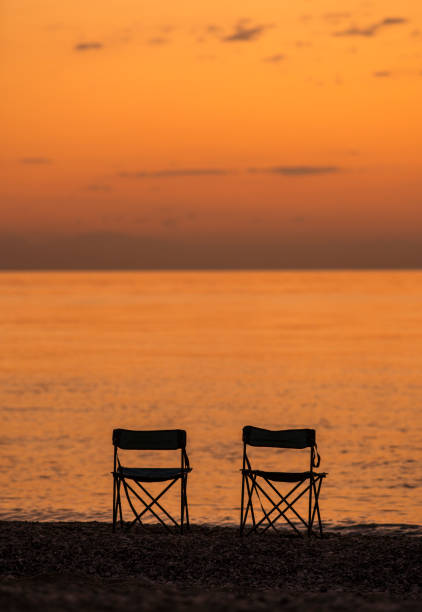 istock Two camp chairs on the beach at sunrise 1173815127
