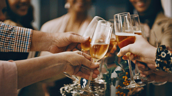 Cropped shot of a group of unrecognizable people toasting their drinking glasses at a wedding