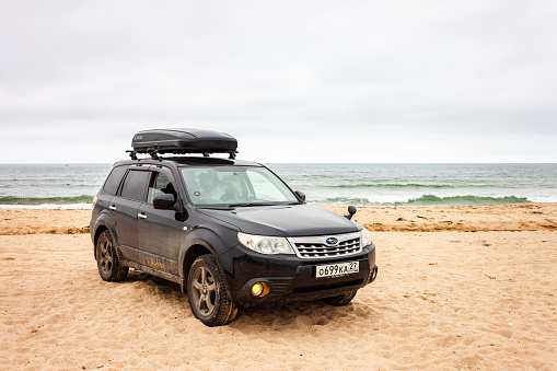 Livadiya, Russia - August 19, 2019: Subaru Forester with trunk box at sand beach