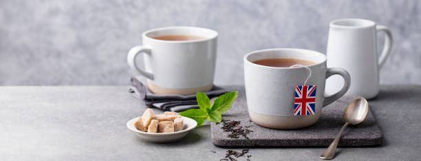 istock Tea in mugs with British flag tea bag label. Grey background. Copy space. 1173820741