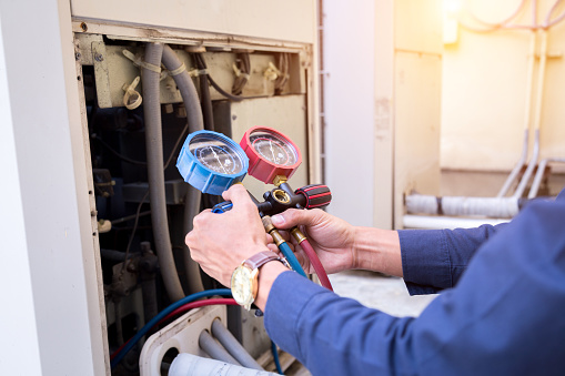 Technician is checking air conditioner ,measuring equipment for filling air conditioners.