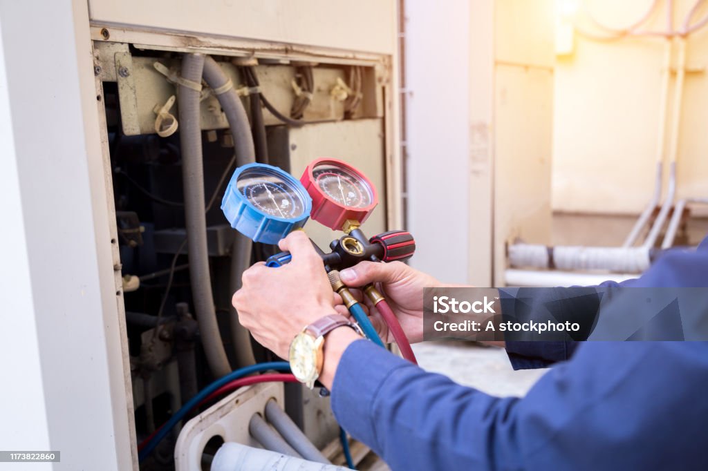 Technician is checking air conditioner ,measuring equipment for filling air conditioners. Air Conditioner Stock Photo
