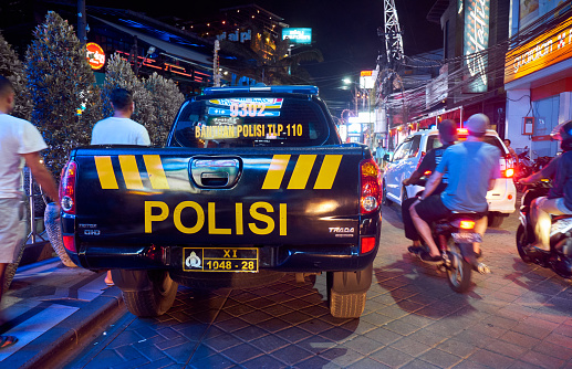 Kuta, Bali, Indonesia - January 11, 2019:  Police car on the road in heavy traffic on the island at night