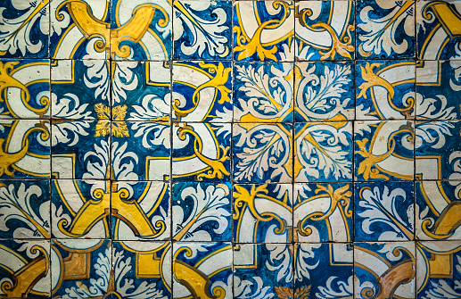 Detail of wall tiles with geometric shapes and vibrant colors on an old facade